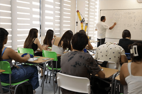 Clase de Preu W con estudiantes y profesor en la pizarra